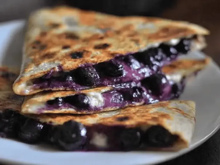 Irresistible blueberry breakfast quesadilla served with fresh blueberries and yogurt, perfect for a quick and healthy breakfast.