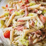Delicious Italian Grinder Pasta Salad with rotini, bell peppers, olives, and creamy dressing, perfect for summer gatherings.